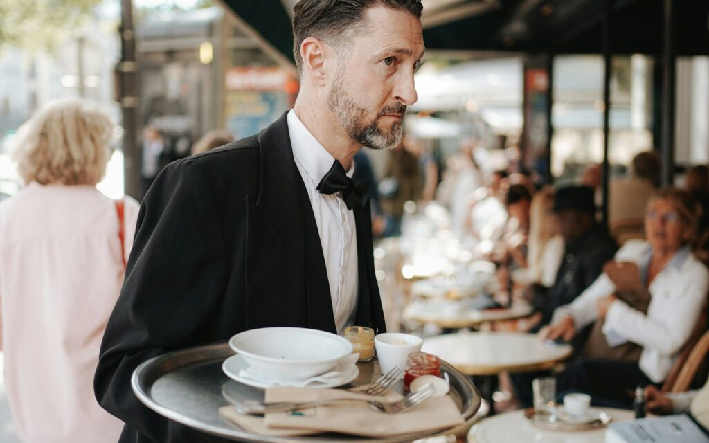 Butler in a tuxedo carrying a serving tray