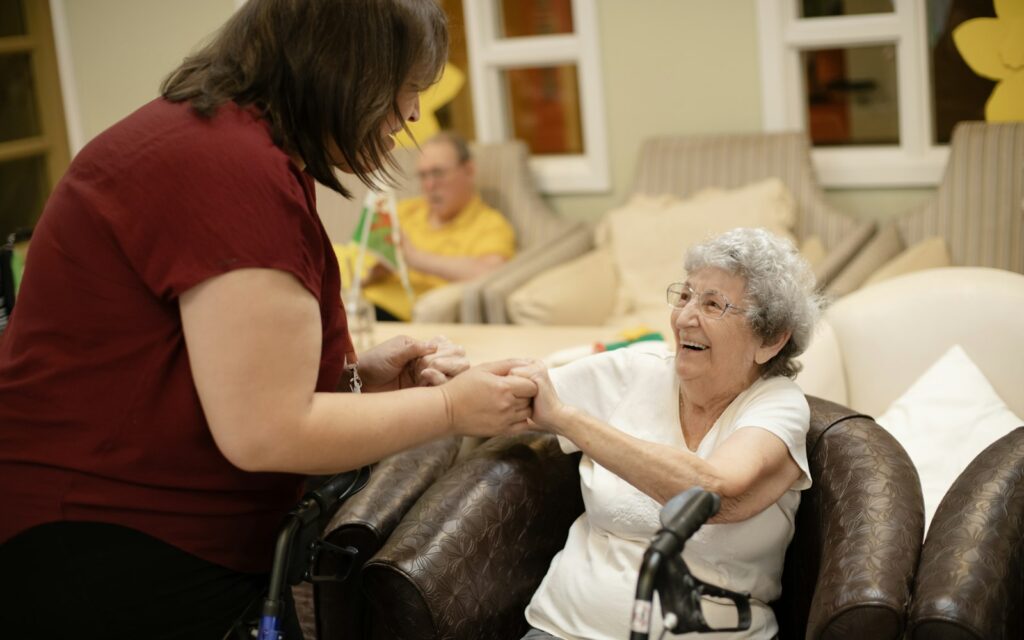 Caregiver helping an elderly woman walk with a walker