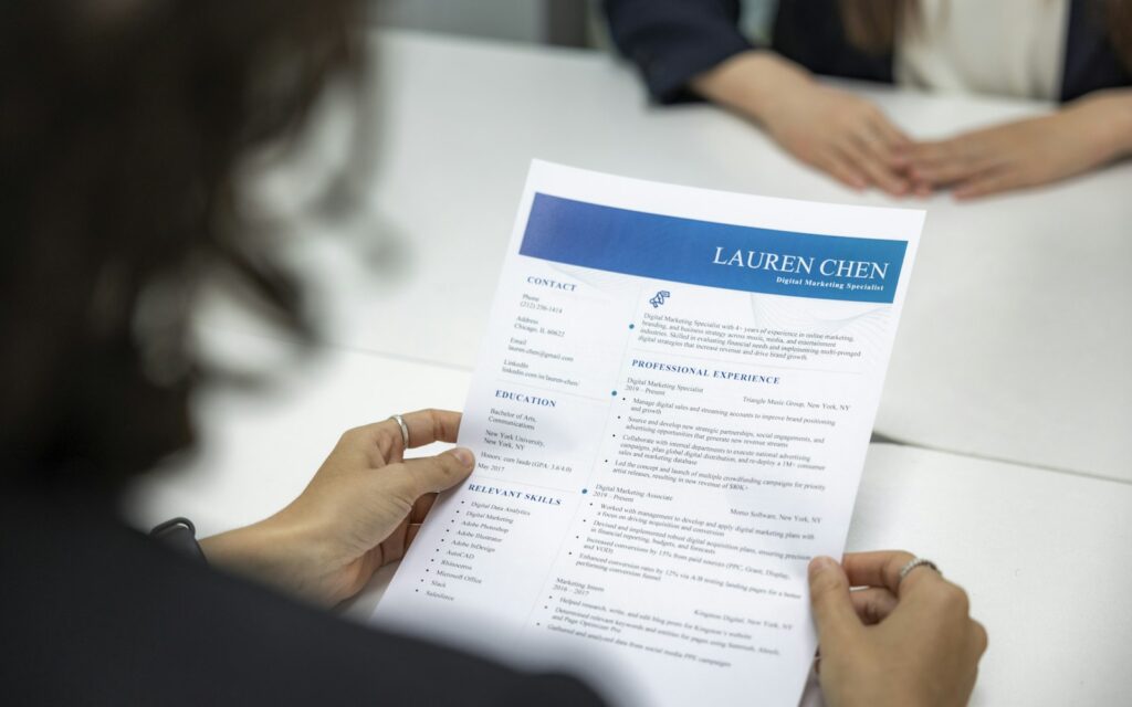 Employer reading a candidate resume at a table